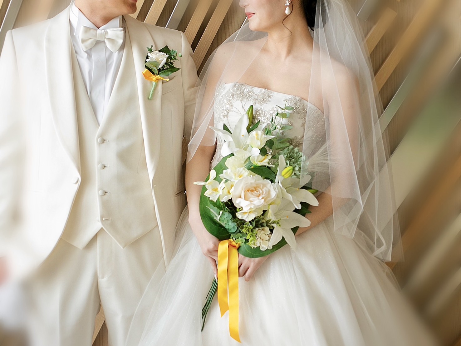 ドレスとタキシード姿の新郎新婦がブーケを持っている写真